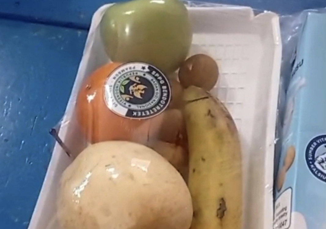 Paket MBG berisi buah dan susu dalam nampan putih di Sidoarjo